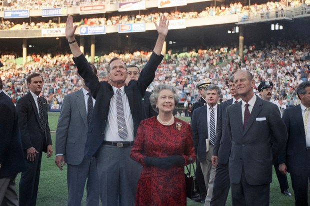 US President George H. W. Bush escorts Queen Elizabeth II and Prince Philip on the field at Memorial Stadium on May 15, 1991, in Baltimore, before the Orioles played the Oakland A's. (AP Photo)