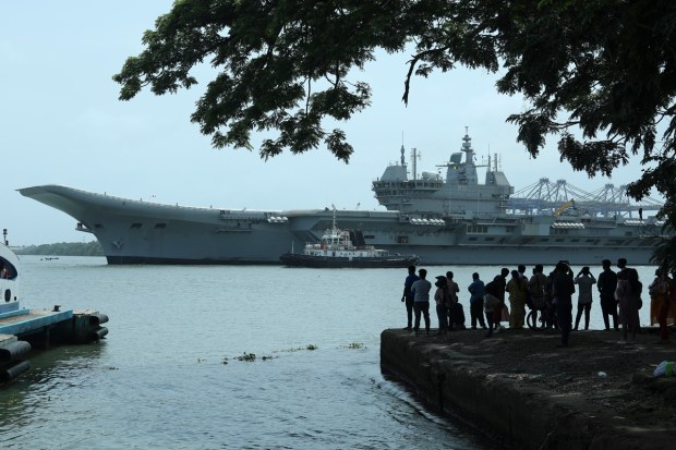 People watch the INS Vikrant leave for trials in the Arabian Sea in Kochi, India, July 2, 2022. India on Friday, Sept. 2, commissioned its first home-built aircraft carrier in its quest to match an aggressive China with a much larger naval fleet. (AP Photo)