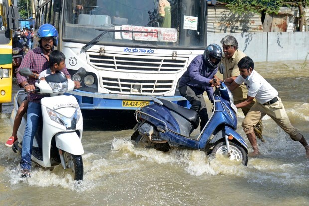 A motorist falls while navigating his way through a flooded street after heavy rainfall in Bangalore, India, Monday, Sept. 5, 2022. Life for many in the southern Indian city of Bengaluru was disrupted on Tuesday after two days of torrential rains set off long traffic snarls, widespread power cuts and heavy floods that swept into homes and submerged roads. (AP Photo)