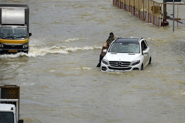 Bengaluru: Commuters push a car stuck on the waterlogged Outer Ring Road after heavy monsoon rains, near Bellandur in Bengaluru, Tuesday, Sep. 6, 2022. (PTI Photo)