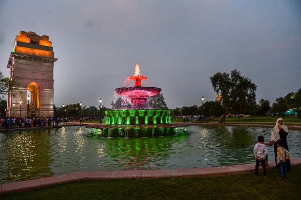 New Delhi: Visitors near an illuminated water fountain at the India Gate, at Kartavya Path in New Delhi. (PTI Photo)