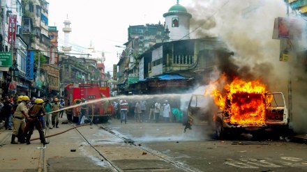 Firefighters try to douse a fire set in a police vehicle by some miscreants near Nakhoda Mosque in Kolkata on Tuesday. (PTI Photo)