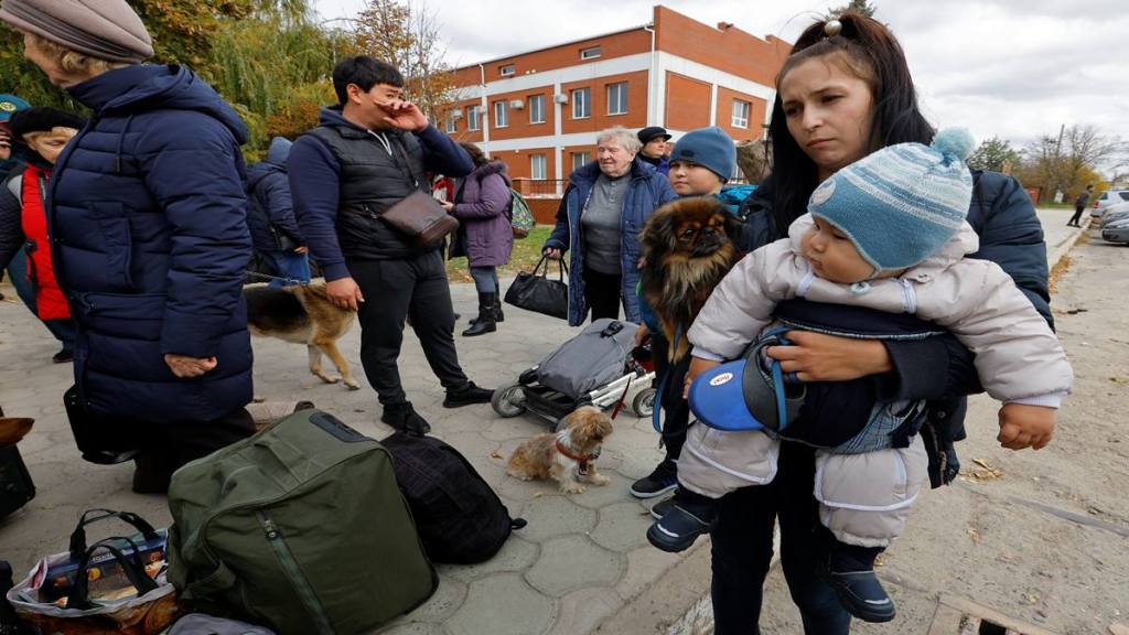 Civilians evacuated from the Russian-controlled city of Kherson wait to board a bus heading to Crimea (Reuters image)