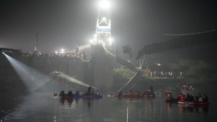Rescuers on boats search in the Machchu river next to a cable suspension bridge that collapsed in Morbi town of western state Gujarat, India, Monday, Oct. 31, 2022. The century-old cable suspension bridge collapsed into the river Sunday evening, sending hundreds plunging in the water, officials said. (AP Photo/Ajit Solanki)