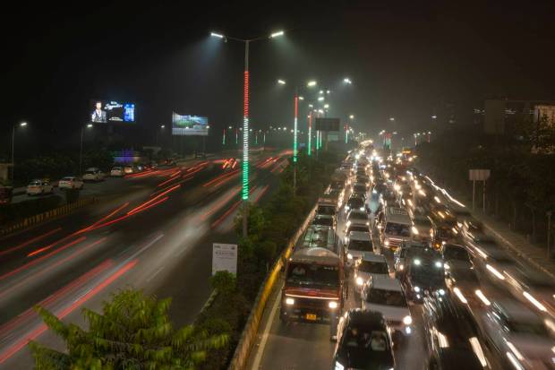 Commuters drive amidst evening haze and toxic smog on the outskirts of New Delhi. (AP Photo)