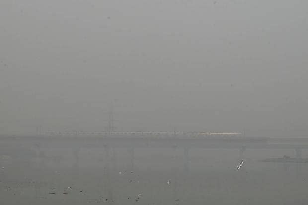 A metro train runs on a bridge enveloped by smog and haze in New Delhi. (AP Photo)