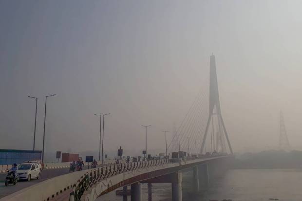 New Delhi: Vehicles ply on the Signature Bridge amid low visibility due to smog, in New Delhi. (PTI Photo)