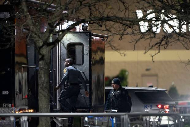 Law enforcement enter a command vehicle as they work the scene of a mass shooting at a Walmart. (AP Photo)
