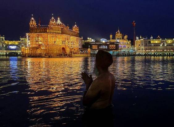 .A Sikh devotee takes a dip in the holy 'sarovar' at Golden Temple on the eve of the birth anniversary of Guru Nanak Dev, in Amritsar, Monday, Nov. 7, 2022. (Photo source:PTI)