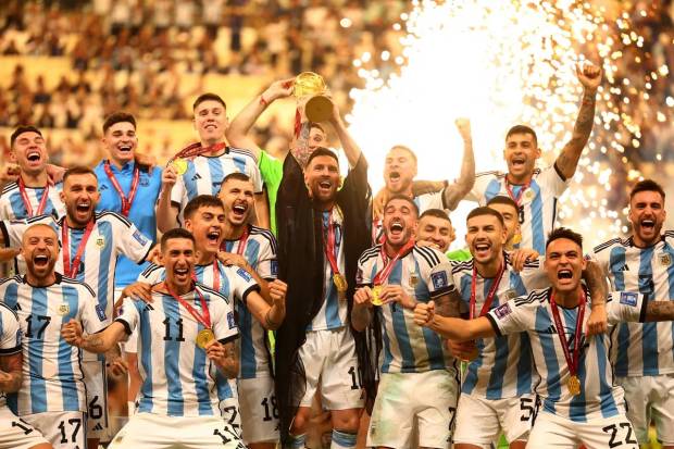Argentina's Lionel Messi lifts the World Cup trophy alongside teammates as they celebrate after winning the World Cup. (Reuters Photo)
