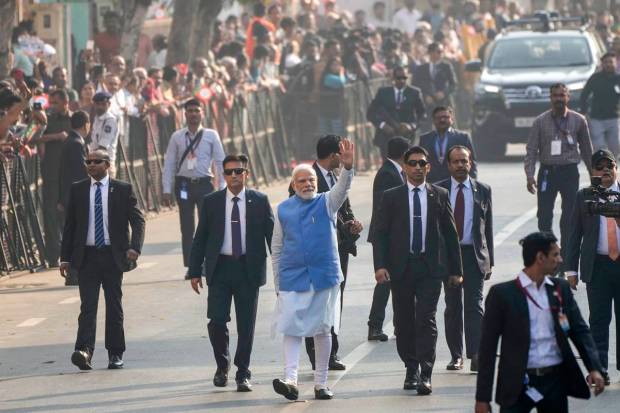 PM Modi waves to people as he arrives to cast his vote during the second phase of Gujarat state legislature elections in Ahmedabad. (AP Photo)
