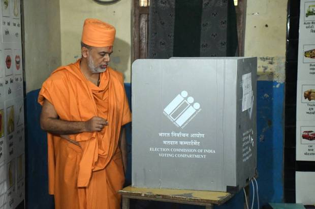 Vadodara: A saint of Swaminarayan Gurukul casts his vote at a polling booth during the second and final phase of Gujarat Assembly elections, in Vadodara. (PTI Photo)