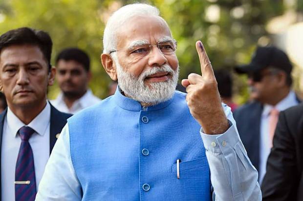 Ahmedabad: Prime Minister Narendra Modi shows his finger marked with indelible ink after casting his vote at a polling booth during the second and final phase of Gujarat Assembly elections, at Ranip area in Ahmedabad. (PTI Photo)