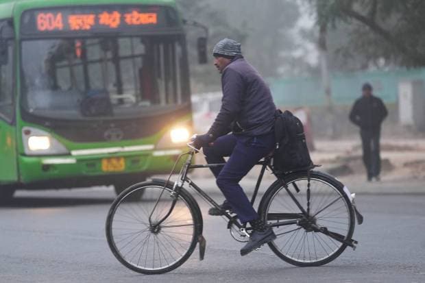A man pedals his cycle during a cold and foggy morning in New Delhi, Wednesday. (PTI Photo)