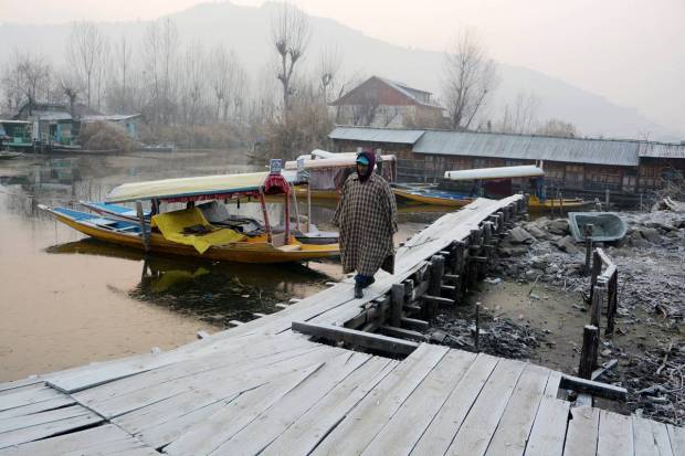 Srinagar: A man walks on frost-covered area as the 40-days harshest winter period Chillai Kalan begins, in Srinagar, Wednesday. (PTI Photo)