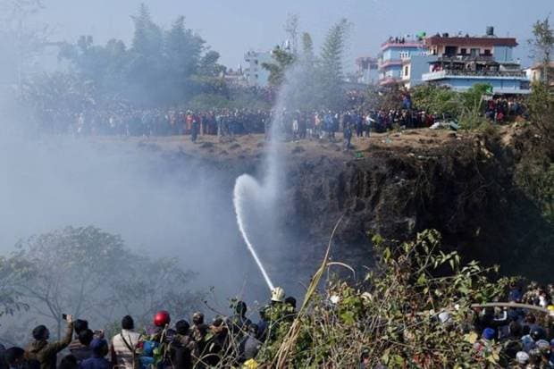 Fire brigade sprays water to douse a fire at the crash site of an aircraft carrying 72 people in Pokhara in western Nepal. REUTERS
