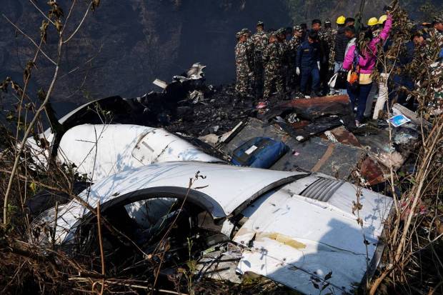 Rescue teams work to retrieve bodies from the wreckage at the crash site of an aircraft carrying 72 people in Pokhara in western Nepal. REUTERS
