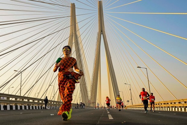 A woman runs the marathon wearing a saree in Mumbai. (Image: PTI)