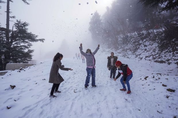 Tourists play with snow after fresh snowfall at Kufri near Shimla. (Image: PTI)
