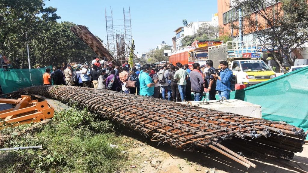 People gather at the accident site where a half broken iron structure of a metro pillar fell, at Hennur Main Road in Bengaluru, Tuesday, Jan. 10, 2023. (PTI Photo)
