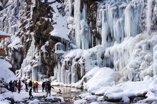 Tangmarg: Tourists visit a frozen waterfall at Drung area of Tangmarg in Baramulla district of north Kashmir. (PTI Photo)
