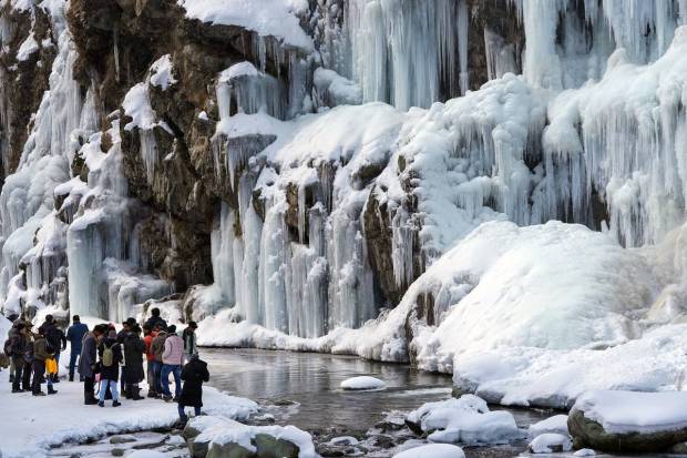 Tangmarg: Tourists visit a frozen waterfall at Drung area of Tangmarg in Baramulla district of north Kashmir. (PTI Photo)