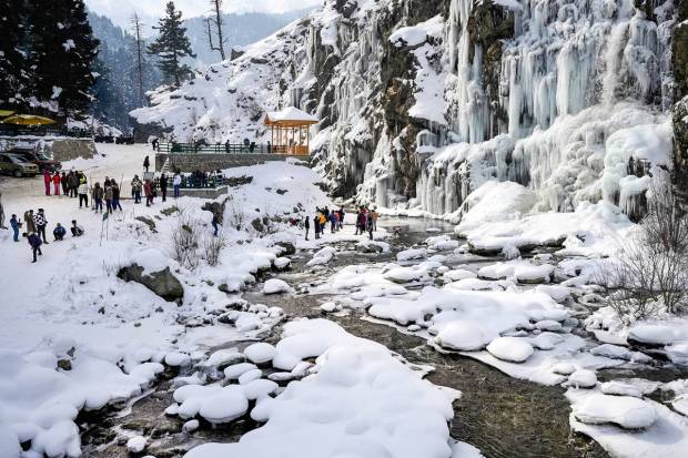 Tangmarg: Tourists visit a frozen waterfall at Drung area of Tangmarg in Baramulla district of north Kashmir. (PTI Photo)