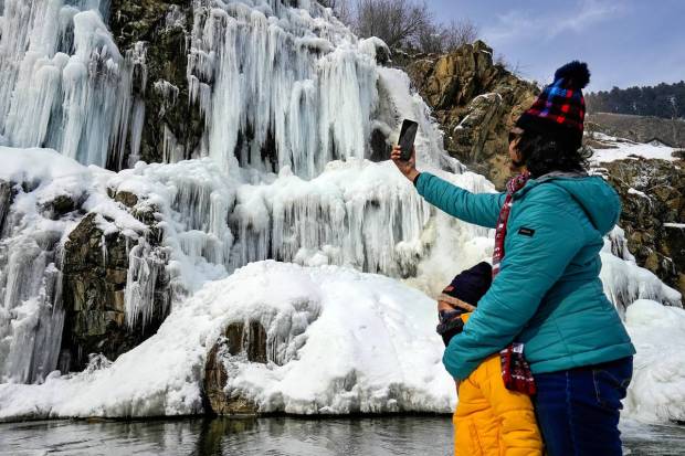 Tangmarg: Tourists visit a frozen waterfall at Drung area of Tangmarg in Baramulla district of north Kashmir. (PTI Photo)