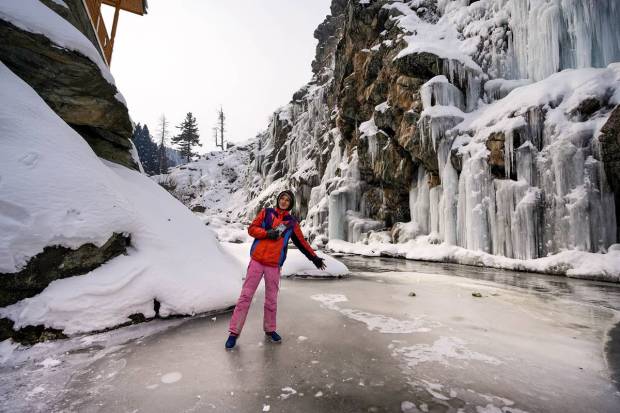 Tangmarg: A local boy stands near a frozen waterfall at Drung area of Tangmarg in Baramulla district of north Kashmir. (PTI Photo)