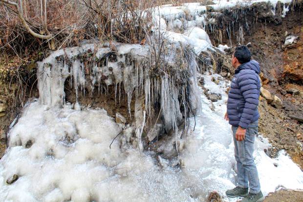 Joshimath: A man looks at frozen water in Subhai village of Joshimath in Chamoli district. (PTI Photo)