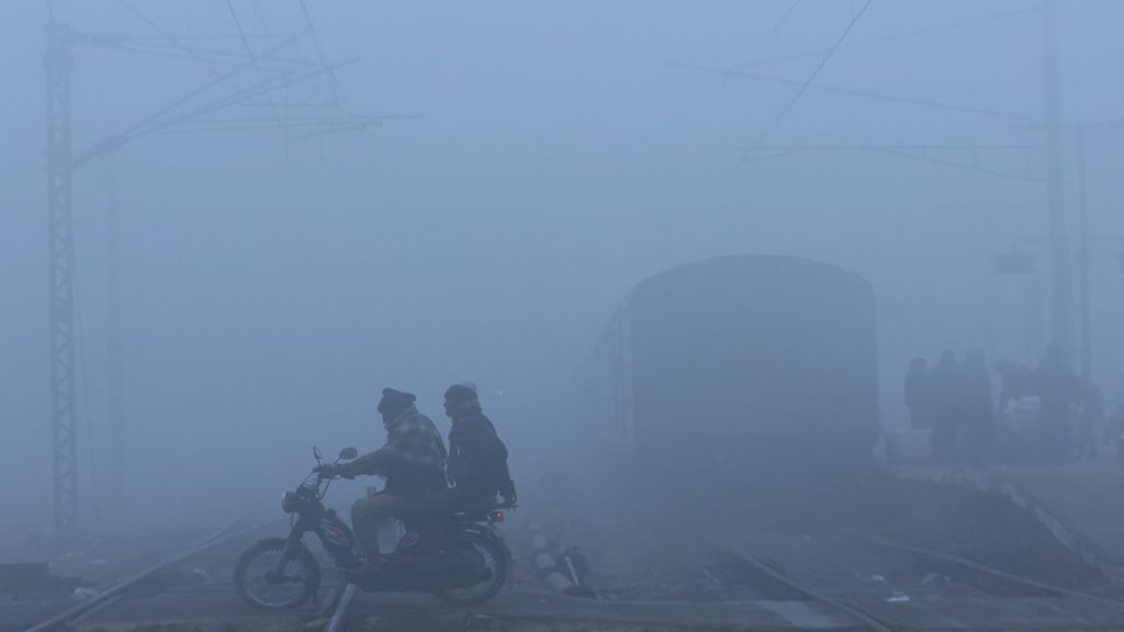 Men on a motorbike cross railway tracks amidst heavy fog on a cold winter morning in New Delhi, India, January 9, 2023. (Photo: REUTERS/Anushree Fadnavis)