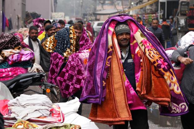 Blanket vendors at a market during a cold winter morning, in New Delhi (PTI Photo)