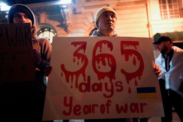 Ukrainians on Friday marked the first anniversary of the Russian invasion. Addressing the citizens, President Volodymyr Zelenskyy has pledged to push for victory in 2023. Visual of a demonstrator holding a banner to show support for Ukraine outside the Russian Consulate in New York City. (Reuters photo)