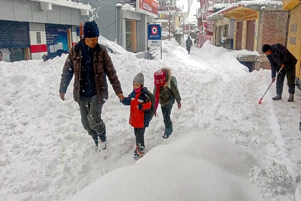 Commuters on a snow-covered road after a fresh spell of snowfall at Keylong. (Image: PTI photo)