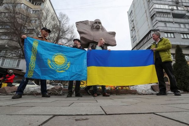 Participants hold flags during a pro-Ukrainian demonstration near a monument to Ukrainian poet Taras Shevchenko in Almaty, Kazakhstan. (Reuters Photo)