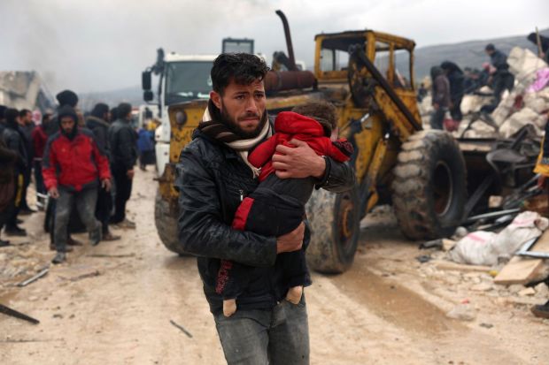 A man carries the body of an earthquake victim in the Besnia village near the Turkish border, Idlib province, Syria, Monday, Feb. 6, 2023. A powerful earthquake has caused significant damage in southeast Turkey and Syria and many casualties are feared. Damage was reported across several Turkish provinces, and rescue teams were being sent from around the country. (Photo/AP)