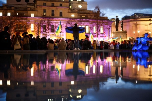 People attend a vigil for Ukraine held on the anniversary of the conflict with Russia, at Trafalgar Square in London. (Reuters photo)