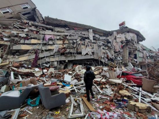 Man stands in front of collapsed buildings following an earthquake in Kahramanmaras, Turkey February 6, 2023. (Photo/Reuters)