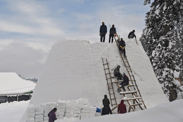 Workers create an igloo at the snow-covered path as the area witnesses heavy snowfall in Jammu and Kashmir's Baramulla. (ANI Image)