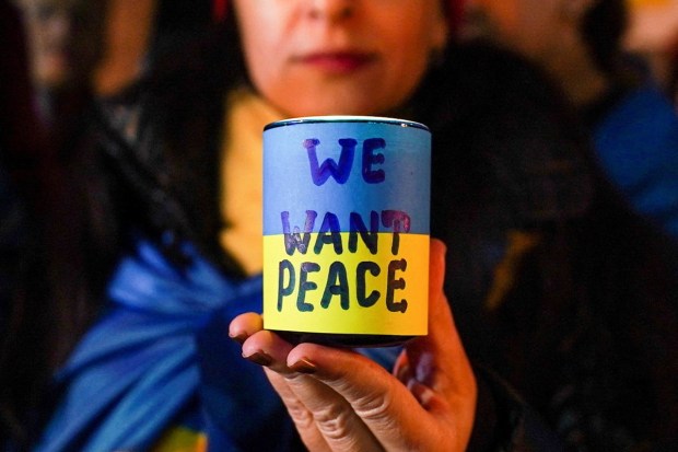 People hold a silent candlelight vigil to show support for Ukraine on the eve of the war's anniversary. (Reuters photo)