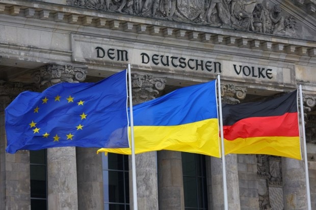 A Ukrainian national flag along with the European Union flag and the German national flag flutters outside the Reichstag building, the seat of Germany's lower house of parliament Bundestag on the first anniversary of the Russian invasion of Ukraine. (Reuters Photo)