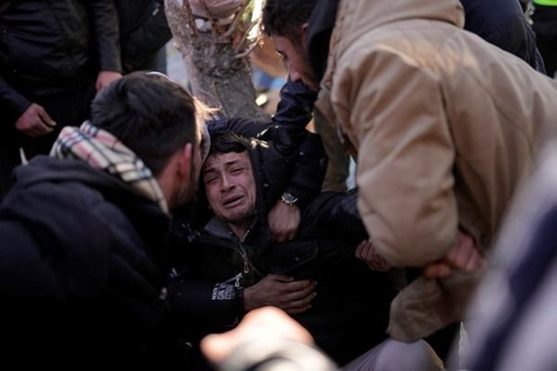 The son of Turkish Durmus Kilinc, center, reacts after rescue team members removed the dead body of his father from a destroyed building, in Elbistan, southeastern Turkey, Thursday, Feb. 9, 2023. (Image: AP Photo/Francisco Seco)