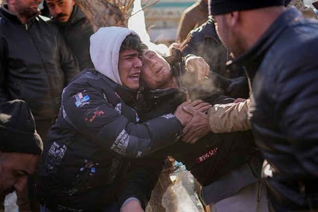 The son of Turkish Durmus Kilinc, center, reacts after rescue team members removed the dead body of his father from a destroyed building, in Elbistan, southeastern Turkey, on Feb. 9, 2023. (Image: AP/PTI)
