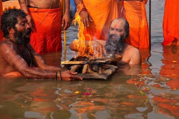 A Sadhu, or Hindu holy man Mauni Baba, offers prayers at the Sangam, the meeting point of the Ganges and the Yamuna rivers, during a ritualistic dip , on the occasion of Maha Shivaratri festival in Prayagraj, in the northern Indian state of Uttar Pradesh. (AP Photo)