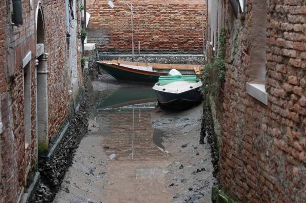 Boats are docked along a dried canal during a low tide in Venice, Italy. Some of Venice's secondary canals have practically dried up lately due a prolonged spell of low tides linked to a lingering high-pressure weather system. (AP Photo)
