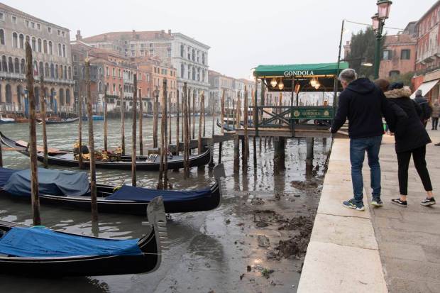 People look at gondolas docked along a canal during a low tide in Venice, Italy. Some of Venice's secondary canals have practically dried up lately due a prolonged spell of low tides linked to a lingering high-pressure weather system. (AP Photo)