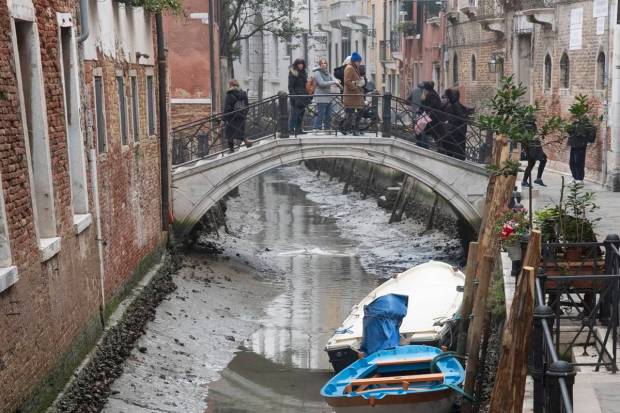 Boats are docked along a dried canal during a low tide in Venice, Italy. Some of Venice's secondary canals have practically dried up lately due a prolonged spell of low tides linked to a lingering high-pressure weather system. (AP Photo)