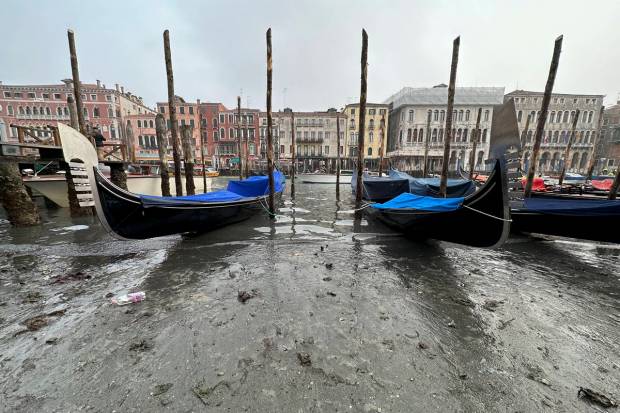 Gondolas are docked along a canal with a low water level during a low tide in Venice, Italy. (AP Photo)