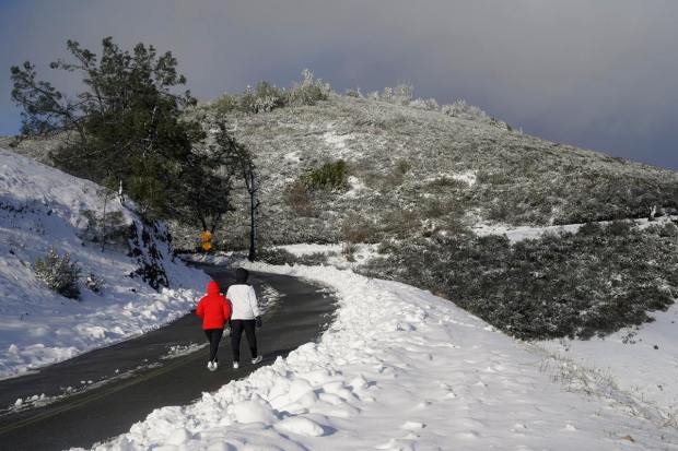 People walk up Summit Road while visiting Mount Diablo State Park in Walnut Creek, Calif., Monday, Feb. 27, 2023. In California, the National Weather Service said a series of winter storm systems will continue moving into the state through Wednesday after residents got a brief break from severe weather Sunday. (AP Photo/Godofredo A. Vásquez)