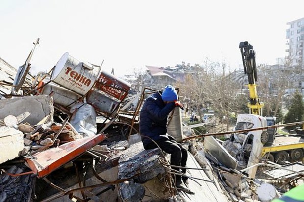 A person reacts while sitting on the rubble of a collapsed building, in the aftermath of an earthquake, in Kahramanmaras, Turkey, February 9, 2023. (Image: REUTERS/Ronen Zvulun)